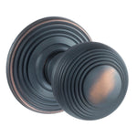 A pair of round antique copper door knobs with concentric ring detailing, shown on a plain white background.