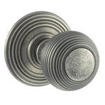 A pair of round distressed silver door knobs with concentric ring detailing, shown on a plain white background.