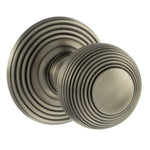 A pair of round matt gun metal door knobs with concentric ring detailing, shown on a plain white background.