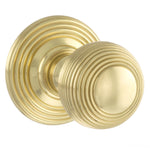 A pair of round brass door knobs with concentric ring detailing, shown on a plain white background.