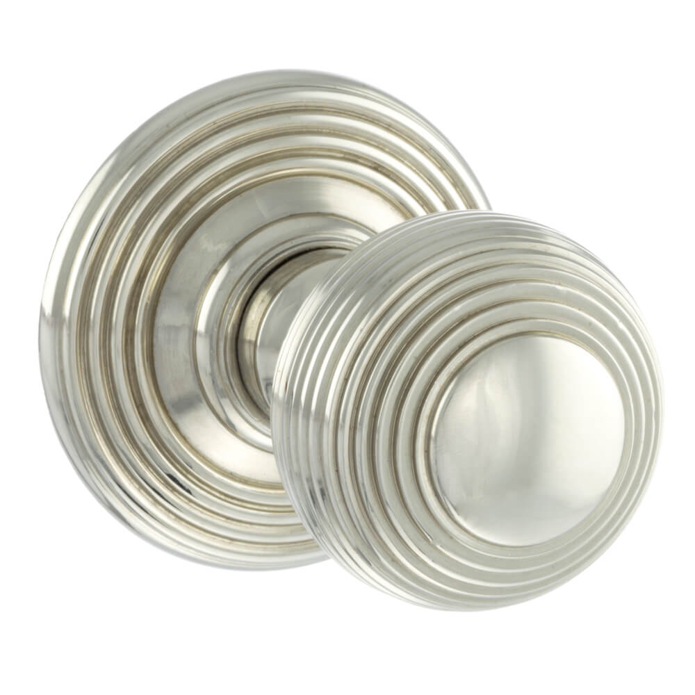 A pair of round silver door knobs with concentric circular grooved detailing, shown on a plain white background.
