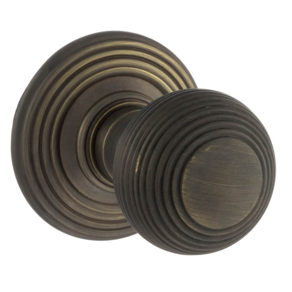 A pair of round door knobs in a dark oil-rubbed bronze finish, featuring concentric circular grooved detailing, shown on a plain white background.