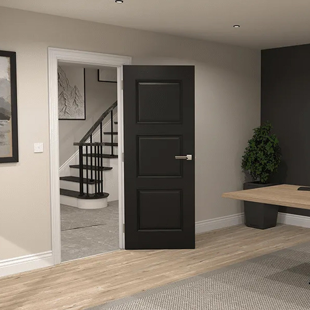 Black door in a room with a staircase and desk.